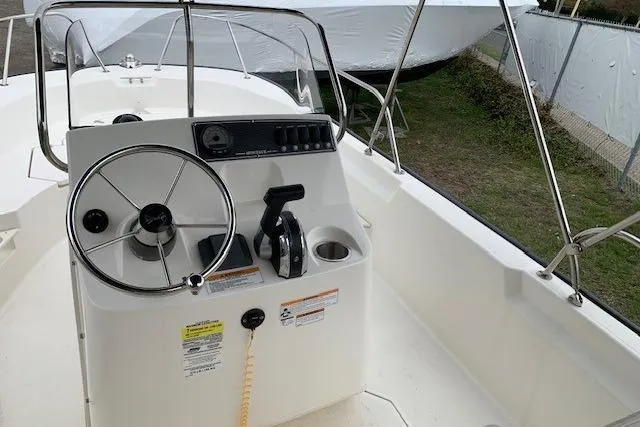 Slide: The Image of 2023 Boston Whaler 170 Montauk boat console with steering wheel and controls. - 21