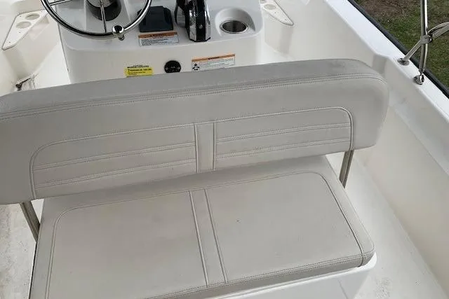 Slide: The Image of 2023 Boston Whaler 170 Montauk boat interior with white seating and steering console. - 26
