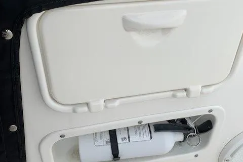 Slide: The Image of 2023 Boston Whaler 170 Montauk boat compartment with fire extinguisher. - 28