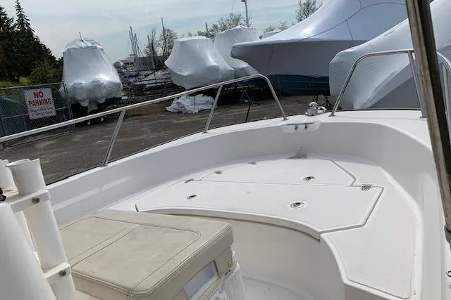 Slide: The Image of 2023 Boston Whaler 170 Montauk boat deck with seating, in a marina with covered boats. - 5