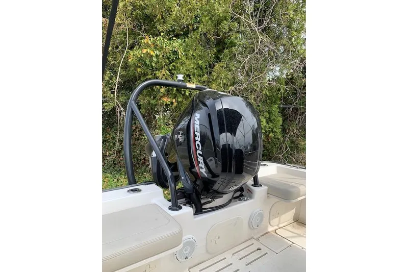 Slide: The Image of 2023 Boston Whaler 170 Montauk with Mercury outboard motor, set against lush greenery. - 7