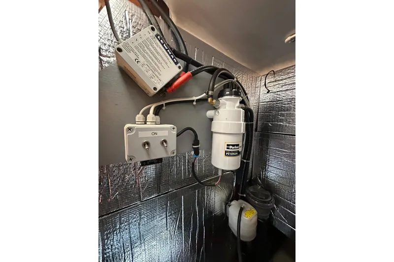 Slide: The Image of Engine compartment of a 2000 Beneteau 50 yacht with fuel filter and electrical components. - 108