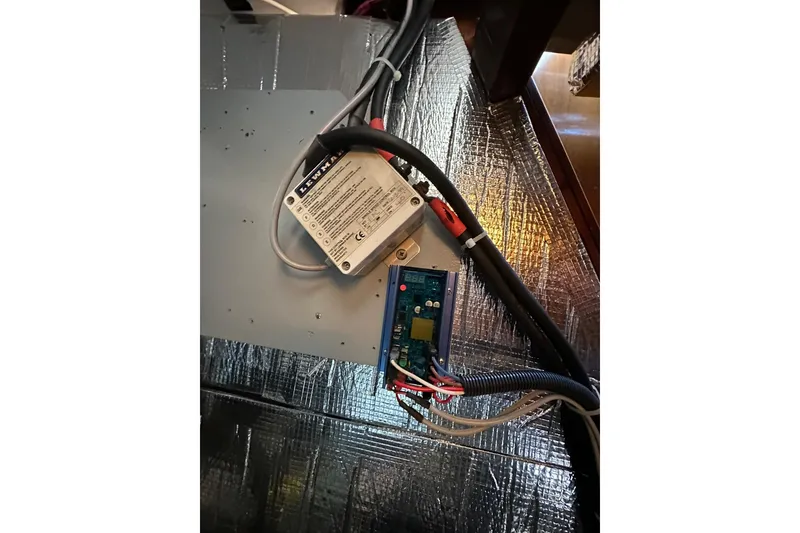 Slide: The Image of Electrical components inside a 2000 Beneteau 50 yacht, featuring wiring and circuit board. - 109