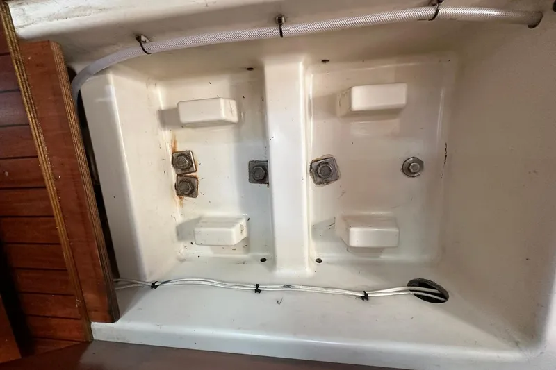 Slide: The Image of Interior view of a 2000 Beneteau 50 sailboat's compartment with visible bolts and wiring. - 113