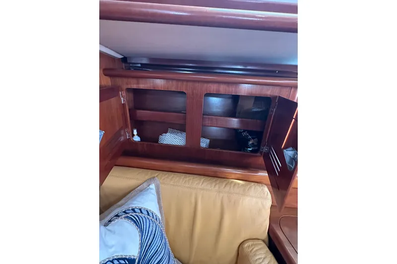 Slide: The Image of Interior of a 2000 Beneteau 50 yacht with wooden cabinetry and beige seating. - 114