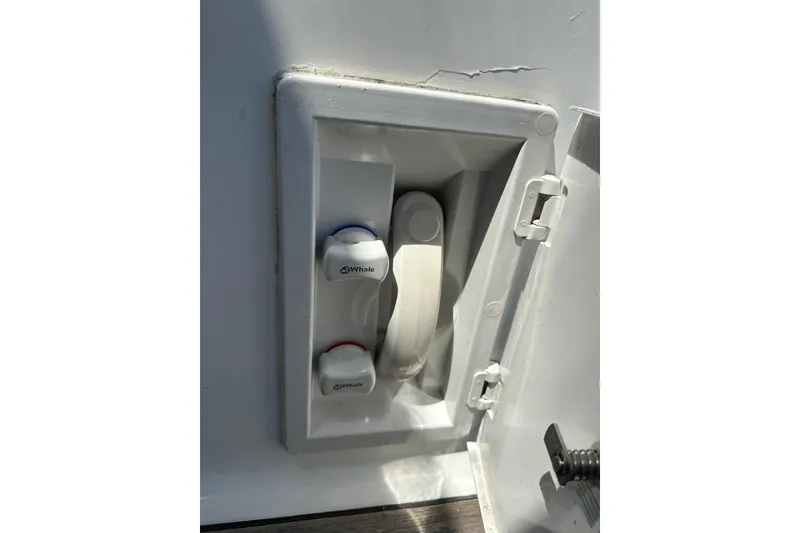 Slide: The Image of Beneteau 50 (2000) boat shower controls with Whale brand knobs in a recessed compartment. - 123