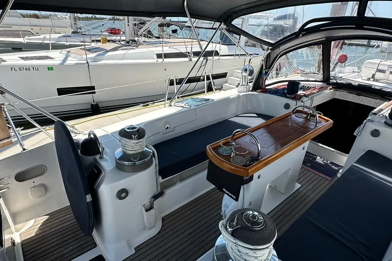 Slide: The Image of Cockpit of a 2000 Beneteau 50 sailboat with seating and winches, docked at a marina. - 17