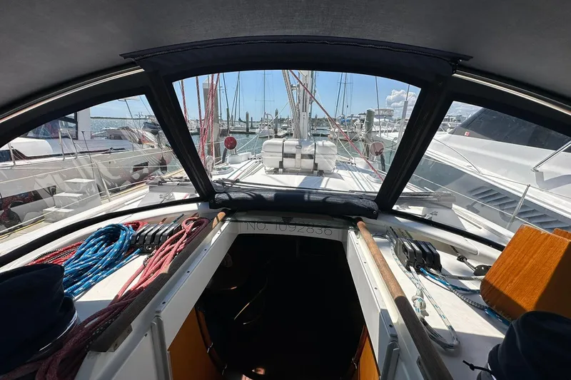 Slide: The Image of Interior view of a 2000 Beneteau 50 sailboat cockpit with ropes and marina background. - 35