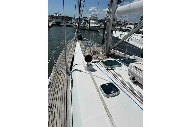 Slide: The Image of Deck view of a 2000 Beneteau 50 sailboat docked at a marina. - 41