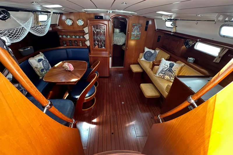 Slide: The Image of Luxurious interior of a 2000 Beneteau 50 yacht with elegant wood finishes and cozy seating. - 64