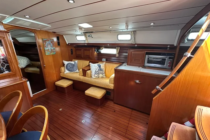 Slide: The Image of Interior of 2000 Beneteau 50 yacht with wooden finish and cozy seating area. - 68