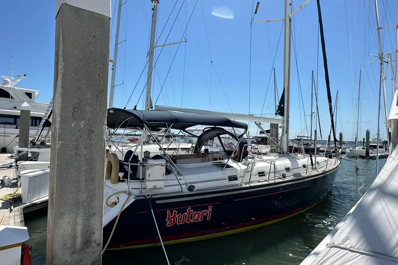 Slide: The Image of 2000 Beneteau 50 sailboat docked at marina under clear blue sky. - 7