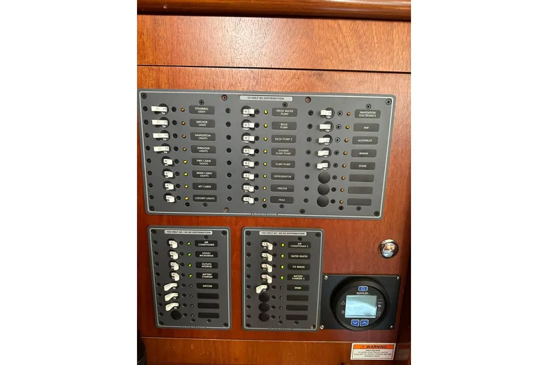 Slide: The Image of Electrical control panel on a 2000 Beneteau 50 yacht, featuring various switches and indicators. - 70