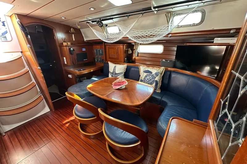 Slide: The Image of Luxurious interior of a 2000 Beneteau 50 yacht with elegant wood finishes and blue seating. - 76