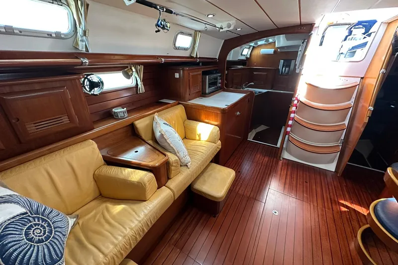 Slide: The Image of Luxurious interior of a 2000 Beneteau 50 yacht with wooden flooring and cozy seating. - 78