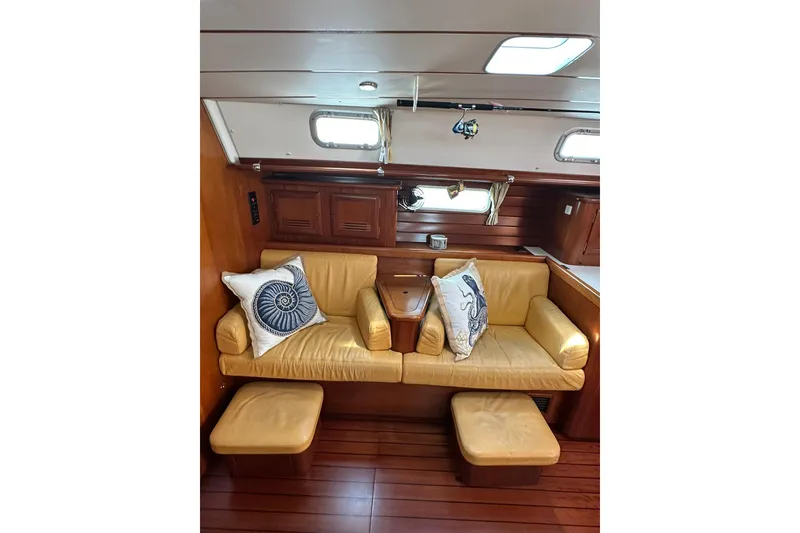 Slide: The Image of Interior of 2000 Beneteau 50 yacht with yellow seating and nautical-themed pillows. - 80