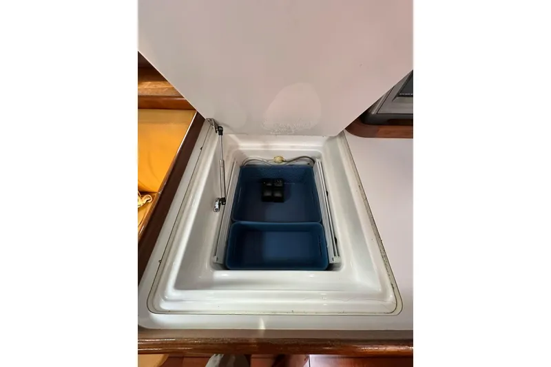 Slide: The Image of Open storage compartment on a 2000 Beneteau 50 yacht, featuring a blue organizer tray. - 81