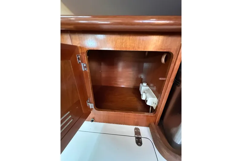 Slide: The Image of Wooden cabinet interior on a 2000 Beneteau 50 yacht, showcasing storage space. - 83