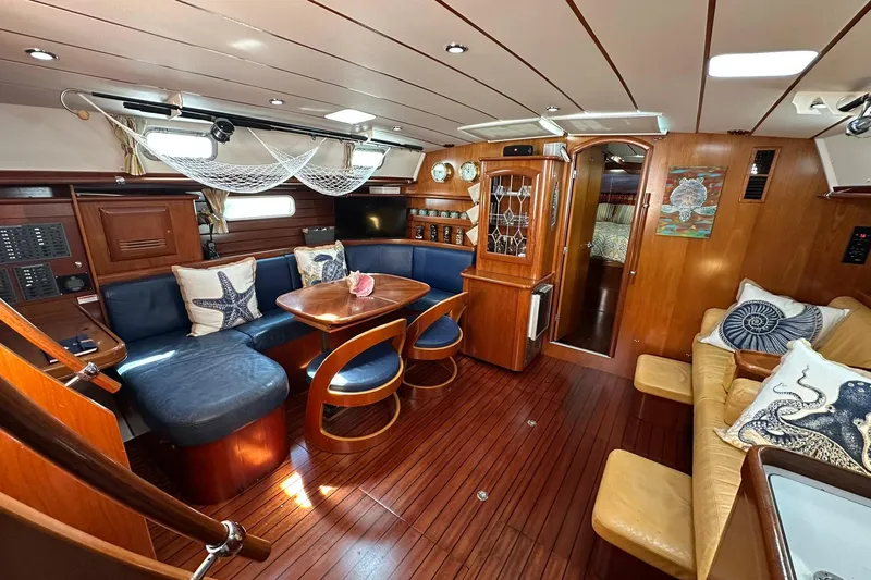 Slide: The Image of Luxurious interior of a 2000 Beneteau 50 yacht with elegant wood finishes and cozy seating. - 90