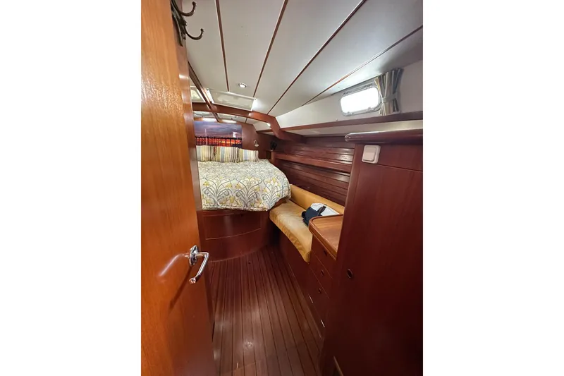 Slide: The Image of Cozy cabin interior of 2000 Beneteau 50 yacht with wooden finishes and bed. - 91