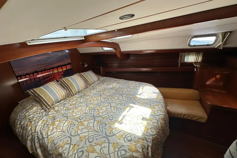 Slide: The Image of Cozy cabin interior of 2000 Beneteau 50 yacht with floral bedding and wood finish. - 93