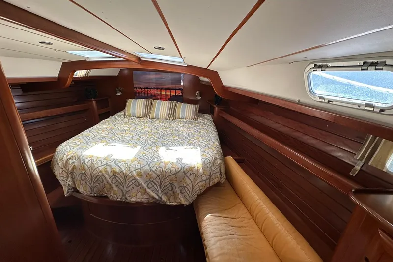 Slide: The Image of Luxurious cabin interior of a 2000 Beneteau 50 yacht with cozy bedding and wooden finishes. - 95
