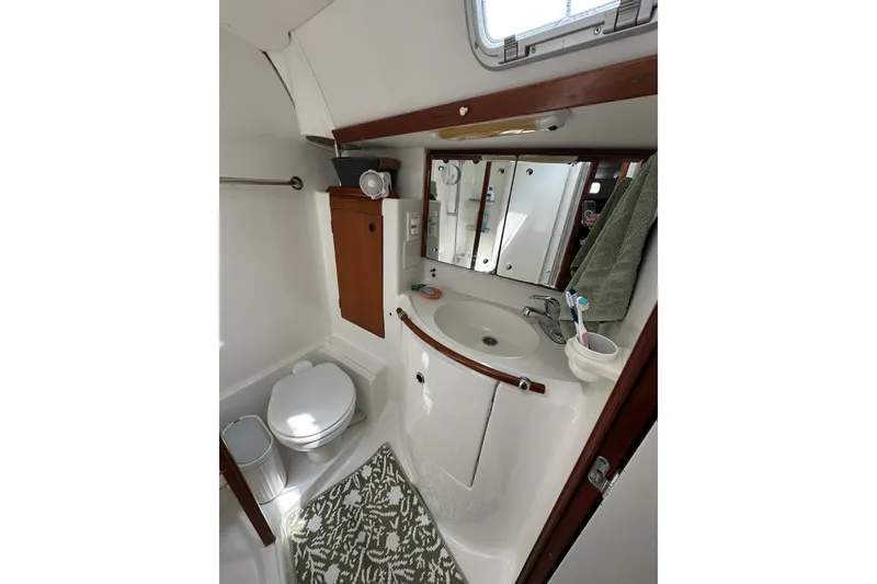 Slide: The Image of Bathroom interior of a 2000 Beneteau 50 yacht, featuring sink, toilet, and mirror. - 98