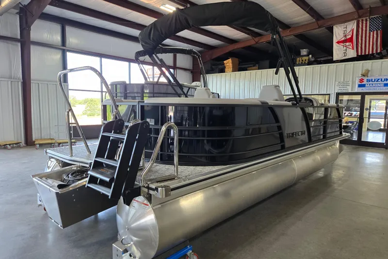 Slide: The Image of 2026 Trifecta 24RF LE 2.75 pontoon boat in showroom, featuring sleek design and modern amenities. - 16