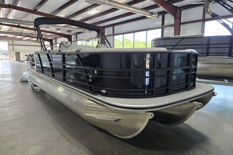 Slide: The Image of 2026 Trifecta 24RF LE 2.75 pontoon boat in a spacious indoor showroom. - 3
