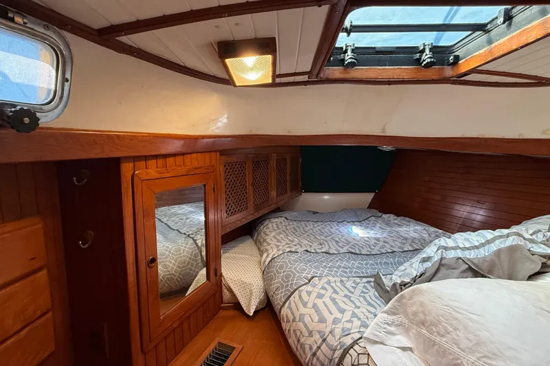 Slide: The Image of Cozy cabin interior of 1986 Westwind 38 sailboat with wooden accents and bedding. - 10