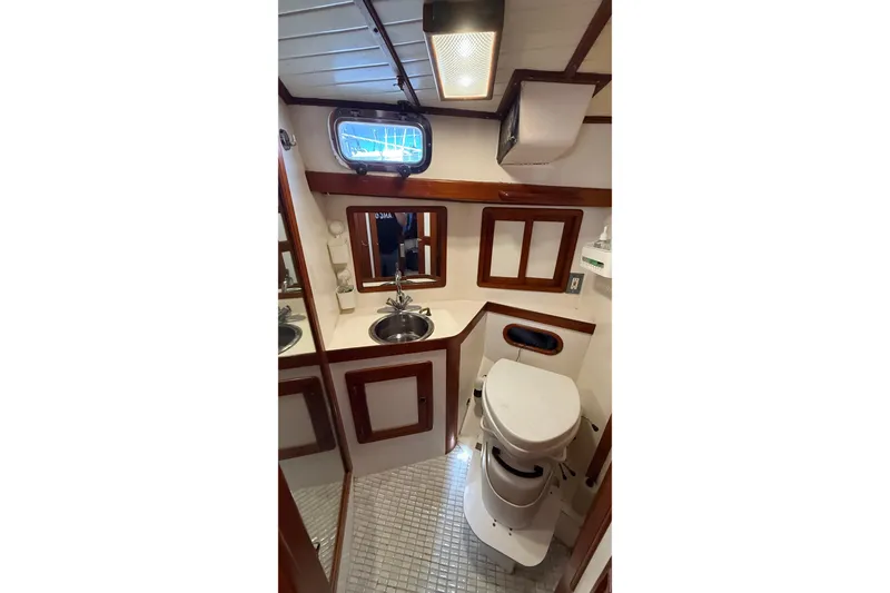Slide: The Image of Interior of 1986 Westwind 38 yacht bathroom with sink, toilet, and wooden accents. - 11