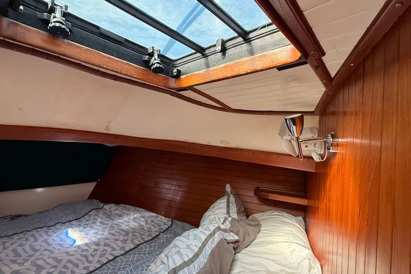 Slide: The Image of Cozy cabin interior of 1986 Westwind 38 sailboat with wooden paneling and skylight. - 13