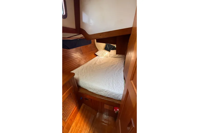 Slide: The Image of Cozy cabin interior of 1986 Westwind 38 sailboat with wooden paneling and comfortable bedding. - 16