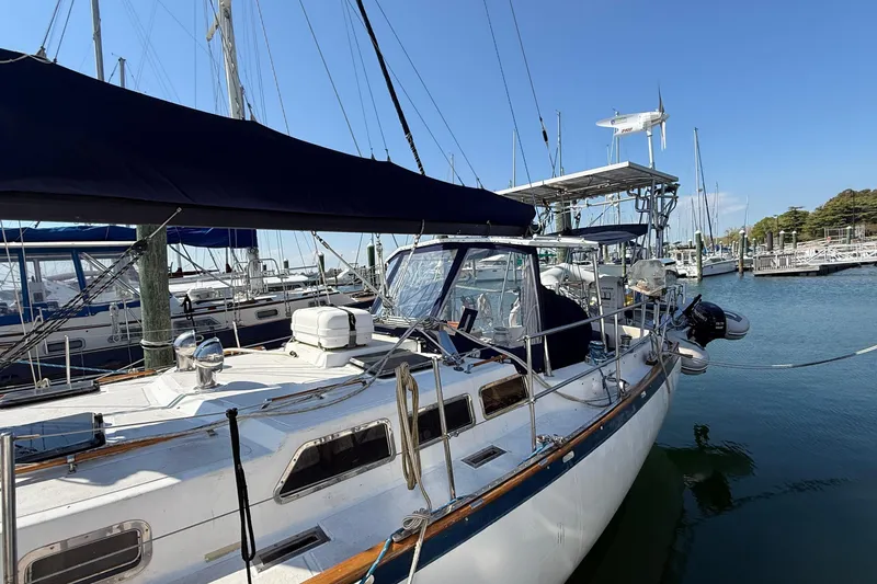Slide: The Image of 1986 Westwind 38 sailboat docked in marina, featuring sleek design and blue canopy. - 3