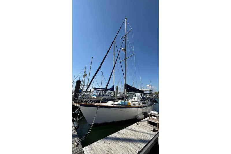 Slide: The Image of 1986 Westwind 38 sailboat docked at marina under clear blue sky. - 6