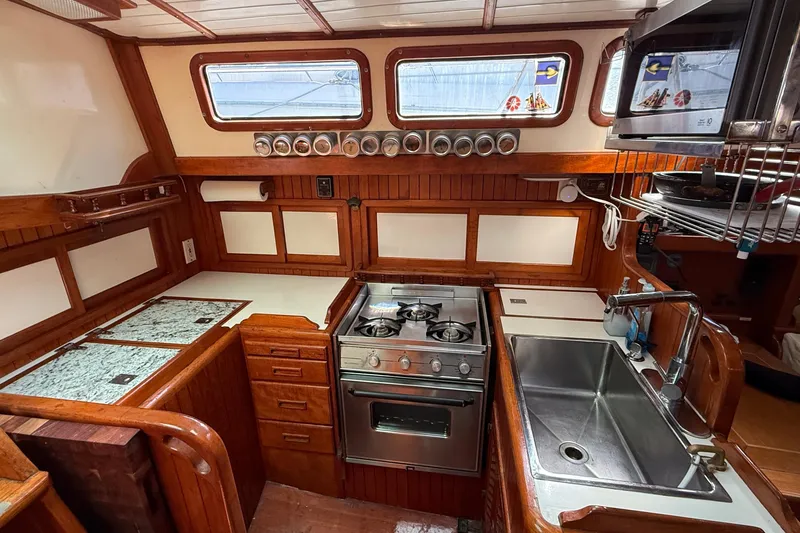 Slide: The Image of Interior of 1986 Westwind 38 yacht kitchen with stove, sink, and wooden cabinetry. - 9