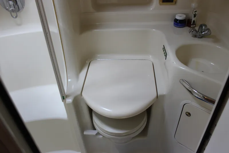 Slide: The Image of Compact bathroom in 2001 Sea Ray 380 Sundancer yacht, featuring toilet and sink. - 24