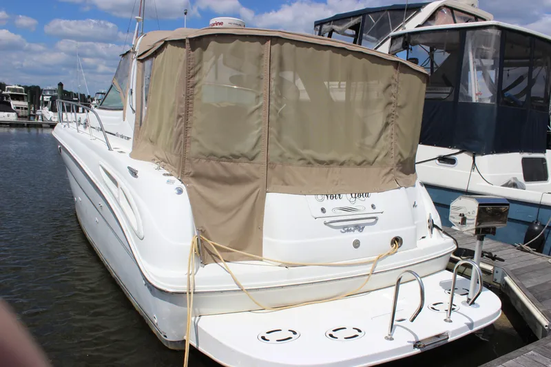 Slide: The Image of 2001 Sea Ray 380 Sundancer docked at marina, featuring beige canopy and white hull. - 3