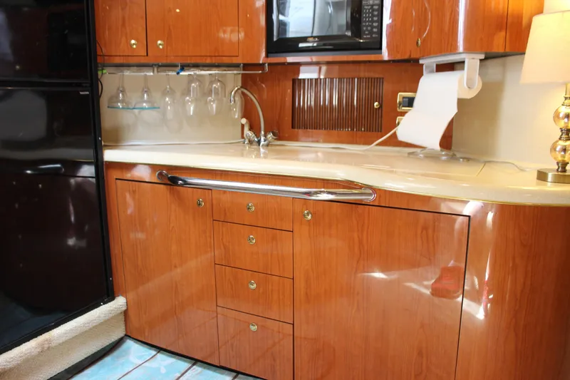 Slide: The Image of 2001 Sea Ray 380 Sundancer kitchen with wood cabinetry, sink, and microwave. - 31