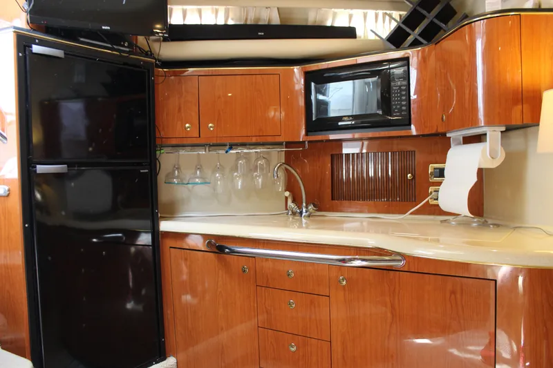 Slide: The Image of Luxurious 2001 Sea Ray 380 Sundancer yacht kitchen with wood cabinetry and modern appliances. - 32