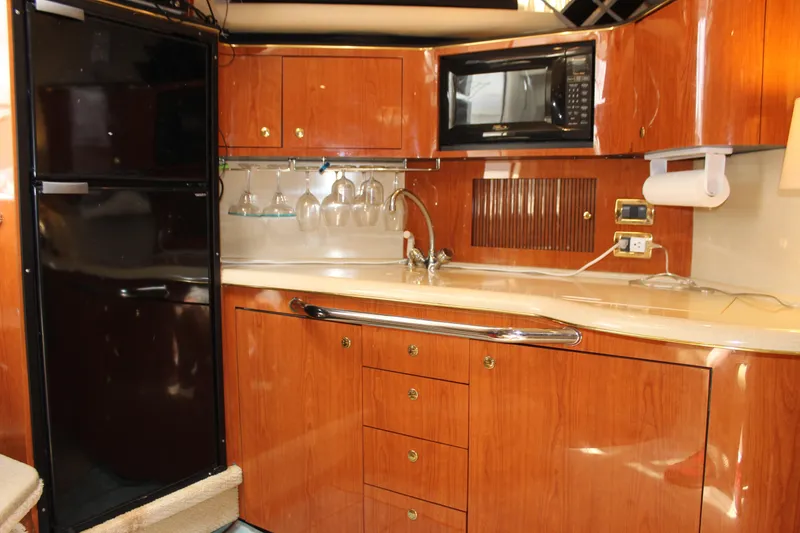 Slide: The Image of Luxurious 2001 Sea Ray 380 Sundancer yacht kitchen with wood cabinetry and modern appliances. - 33