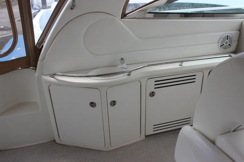 Slide: The Image of Interior view of a 2001 Sea Ray 380 Sundancer yacht, featuring sleek white cabinetry. - 6