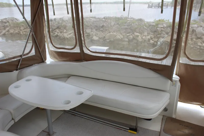 Slide: The Image of Interior of 2001 Sea Ray 380 Sundancer with white seating and table, overlooking water. - 9