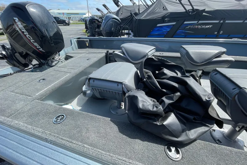 Slide: The Image of 2023 Starcraft Storm 176 SC boat interior with Mercury engine, featuring seating and storage. - 2