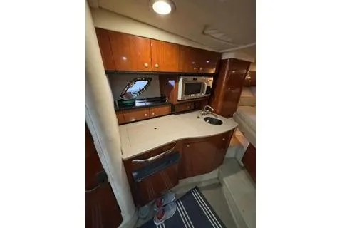 Slide: The Image of 2007 Sea Ray Sundancer 310 cabin interior with kitchenette and wood cabinetry. - 19