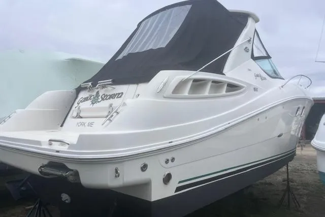 Slide: The Image of 2007 Sea Ray Sundancer 310 boat with black canopy, docked on land. - 2