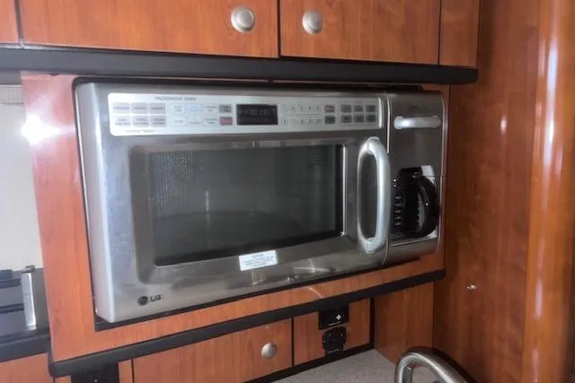Slide: The Image of Microwave in 2007 Sea Ray Sundancer 310 yacht kitchen with wooden cabinetry. - 20