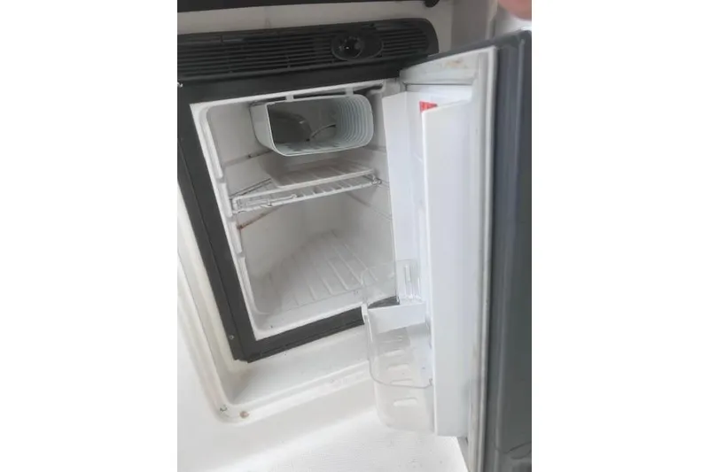 Slide: The Image of Open refrigerator inside a 2007 Sea Ray Sundancer 310 boat, showing empty shelves. - 22