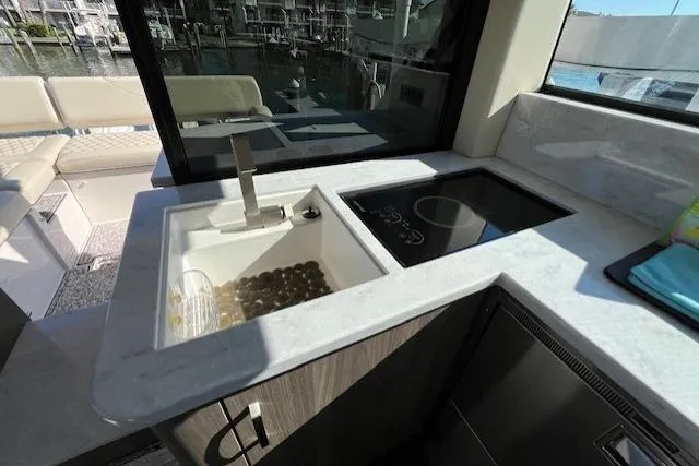Slide: The Image of Modern kitchen area on 2022 Regal 38 XO yacht with sink and cooktop. - 7