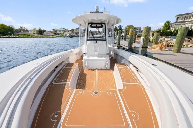 Slide: The Image of 2024 Regulator 34 boat docked, featuring spacious deck and modern design. - 10